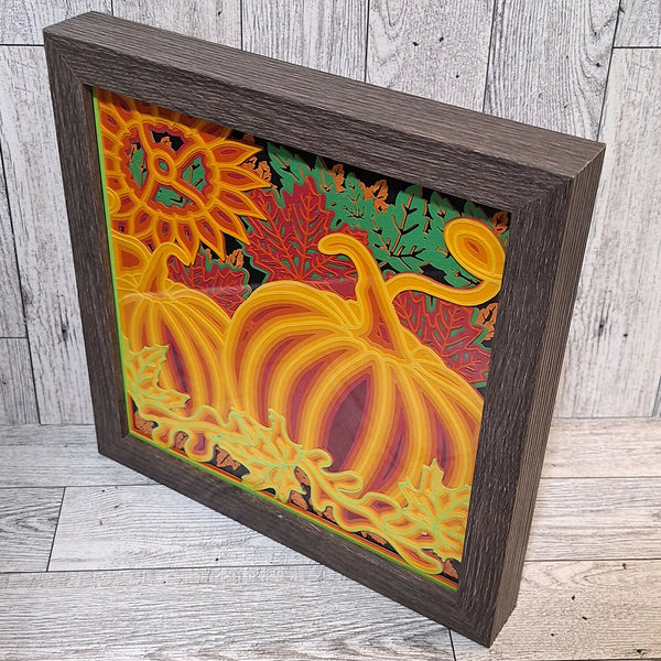 Side view of Brown framed paper cut image of pumpkins and fall leaves