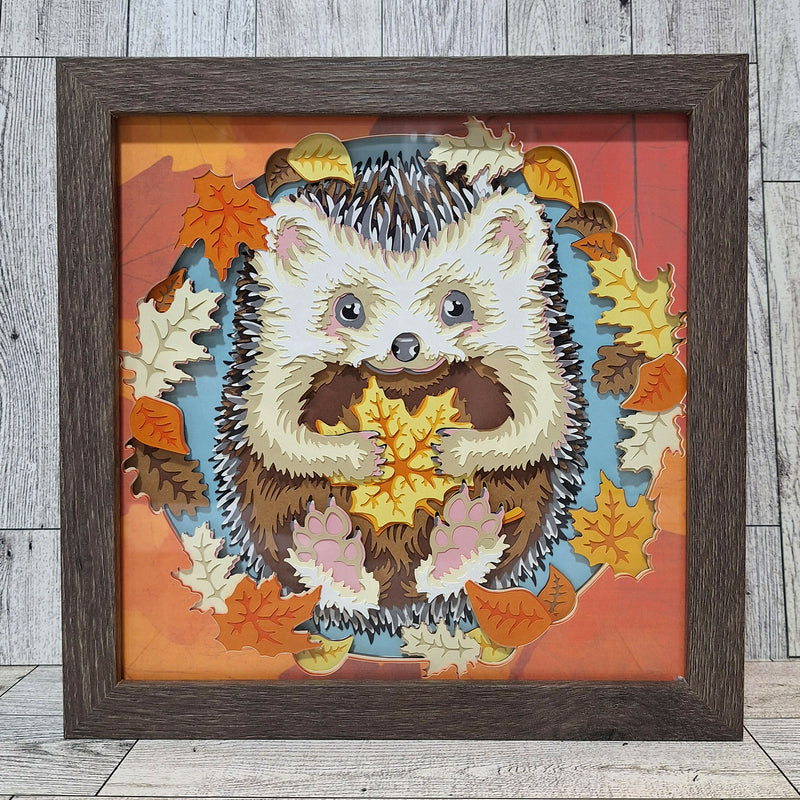 framed hedgehog holding a fall leaf