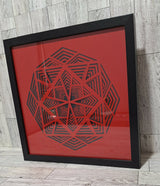 angled view of framed black and red paper