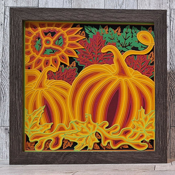 Brown framed paper cut image of pumpkins and fall leaves