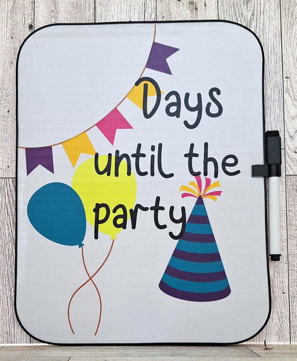 Whiteboard with balloons, banner, and party hat